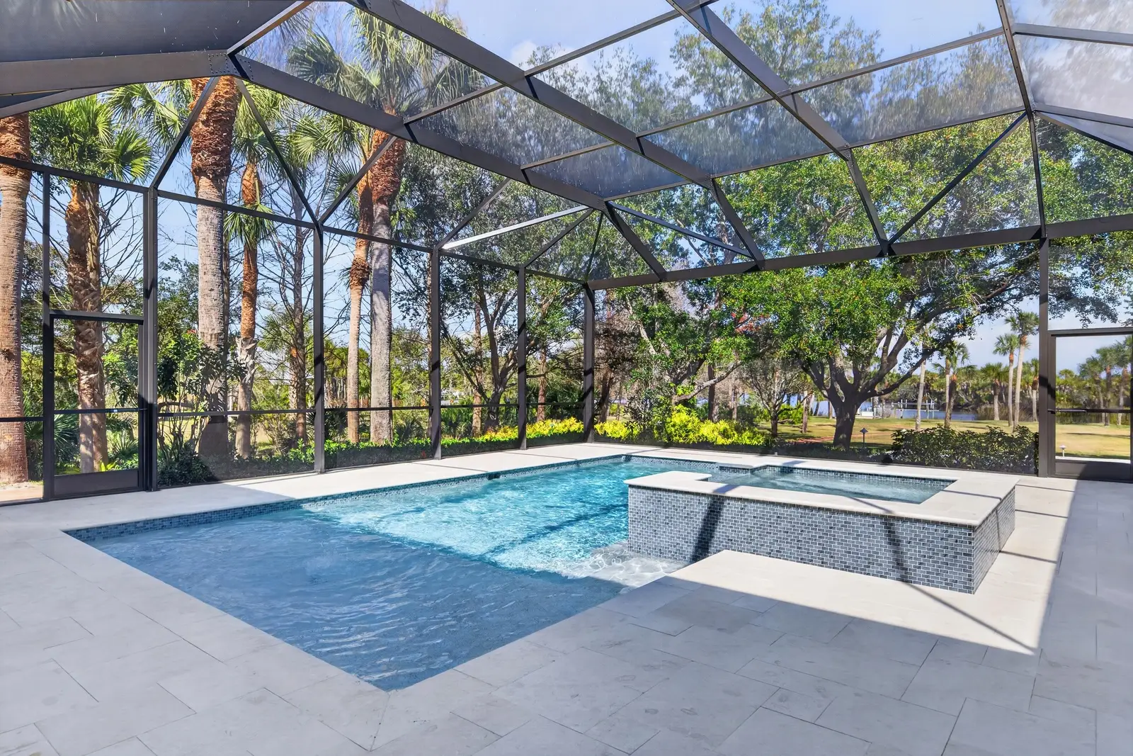 Pool with screened lanai jacuzzi and palm trees in Venice FL home remodel